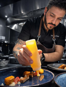 Pass finishing • Final dots Chef finishing a plate during service