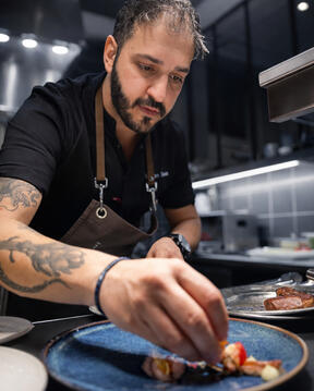 Service plating — fine dining Chef George Tanos plating a dish during service in a professional kitchen